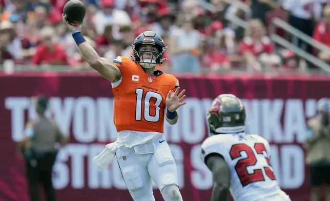 Denver Broncos quarterback Bo Nix (10) throws a pass over Tampa Bay Buccaneers safety Tykee Smith (23) during the first half of an NFL football game, in Tampa, Fla. on Sunday, Sept. 22, 2024. (AP Photo/Chris O'Meara)