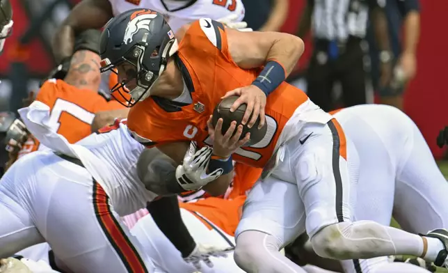 Denver Broncos quarterback Bo Nix runs for a first down against the Tampa Bay Buccaneers on a fourth and one play during the first half of an NFL football game, in Tampa, Fla. on Sunday, Sept. 22, 2024. (AP Photo/Jason Behnken)