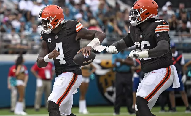 Cleveland Browns quarterback Deshaun Watson (4) celebrates his one-yard touchdown run with offensive tackle James Hudson III (66) during the first half of an NFL football game Sunday, Sept. 15, 2024, in Jacksonville, Fla. (AP Photo/Phelan M. Ebenhack)