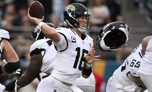 Jacksonville Jaguars quarterback Trevor Lawrence (16) throwsw a pass as a teammates helmet flies off during the second half of an NFL football game against the Cleveland Browns Sunday, Sept. 15, 2024, in Jacksonville, Fla. (AP Photo/Phelan M. Ebenhack)