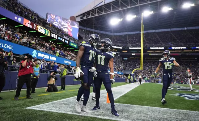 Seattle Seahawks wide receiver Jaxon Smith-Njigba (11) celebrates with wide receiver DK Metcalf (14) after Metcalf scored a touchdown during a preseason NFL football game against the Cleveland Browns, Saturday, Aug. 24, 2024, in Seattle. (AP Photo/Lindsey Wasson)