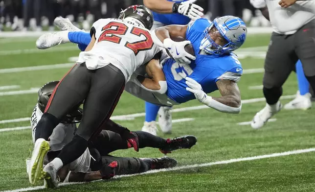 Detroit Lions running back David Montgomery (5) is stopped by Tampa Bay Buccaneers cornerback Zyon McCollum (27) during the first half of an NFL football game, Sunday, Sept. 15, 2024, in Detroit. (AP Photo/Paul Sancya)