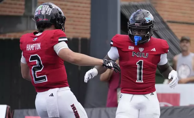 Northern Illinois running back Antario Brown (1) celebrates his his second touchdown of the day with quarterback Ethan Hampton during the first half of an NCAA college football game against Buffalo on Saturday, Sept. 21, 2024, in DeKalb, Ill. (AP Photo/Charles Rex Arbogast)