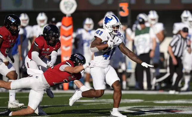 Buffalo running back Al-Jay Henderson breaks the tackle of Northern Illinois safety Jordan Hansen and heads to the end zone for a touchdown during the second half of an NCAA college football game Saturday, Sept. 21, 2024, in DeKalb, Ill. (AP Photo/Charles Rex Arbogast)