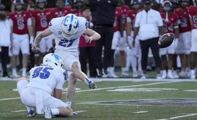 Buffalo place kicker Upton Bellenfant kicks the game winning field goal off the hold of Ethan Duane, during the team's 23-20 upset overtime win in an NCAA college football game Saturday, Sept. 21, 2024, in DeKalb, Ill. (AP Photo/Charles Rex Arbogast)