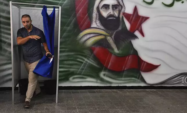 CORRECTS DATE - A voter prepares to cast his ballot inside a polling station during the presidential election, Saturday, Sept. 7, 2024, in Algiers, Algeria. (AP Photo/Fateh Guidoum)