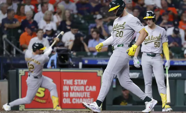 CORRECTS NAME TO ZACK GELOF NOT RYAN NODA - Oakland Athletics' Zack Gelof (20) touches the plate after his solo home run as Max Schuemann, left, and Armando Alvarez (50) wait on deck during the second inning of a baseball game against the Houston Astros Tuesday, Sept. 10, 2024, in Houston. (AP Photo/Michael Wyke)