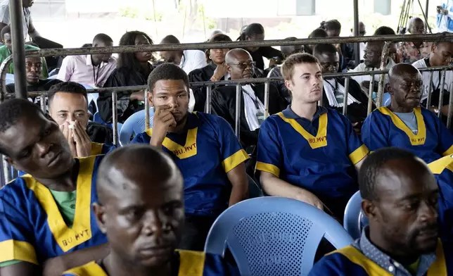 CORRECTS ID: Along the back row shows from left; Benjamin Reuben Zalman-Polun, Marcel Malanga and Tyler Thompson, all American citizens, attend a court verdict in Congo, Kinshasa, Friday, Sept. 13, 2024, on charges of taking part in a coup attempt in May 2024. (AP Photo/Samy Ntumba Shambuyi)