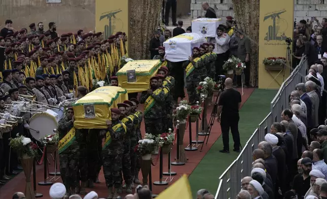 CORRECTS DAY TO TUESDAY WHEN KILLED Hezbollah fighters carry the coffins of fallen four comrades who were killed Tuesday after their handheld pagers exploded, during their funeral procession in the southern suburb of Beirut, Lebanon, Wednesday, Sept. 18, 2024. (AP Photo/Bilal Hussein)