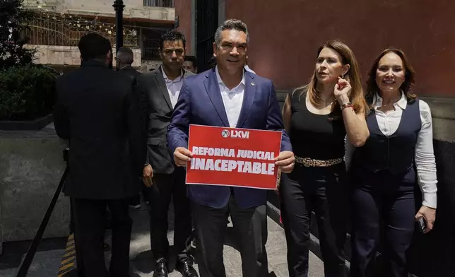 CORRECTS TO REMOVE THAT SENATORS ARE DISCUSSING JUDICIAL REFORM - Alejandro Moreno, Institutional Revolutionary Party leader, holds a sign with a message that reads in Spanish: "Judicial Reform unacceptable", outside an alternate headquarters for senators in Mexico City, Thursday, Sept. 5, 2024, one day after Mexico's lower house approved the legislation. (AP Photo/Felix Marquez)