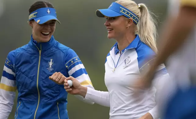 CORRECTS ID AT LEFT TO ESTHER HENSELEIT, NOT LINN GRANT- Europe's Charley Hull, right, is congratulated by Esther Henseleit after making a putt on the 10th hole during a Solheim Cup golf tournament foursomes match at Robert Trent Jones Golf Club, Friday, Sept. 13, 2024, in Gainesville, Va. (AP Photo/Matt York)