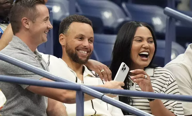 CORRECTS SPELLING OF FIRST NAME TO STEPHEN, NOT SPETH, ADDS WIFE's NAME - Stephen Curry, center, and his wife Ayesha Curry arrive for the women's singles final of the U.S. Open tennis championships between Aryna Sabalenka, of Belarus, and Jessica Pegula, of the United States, Saturday, Sept. 7, 2024, in New York. (AP Photo/Frank Franklin II)