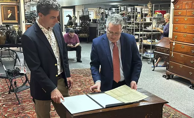 CORRECTS NAME TO BRUNK AUCTIONS - Auctioneer Andrew Brunk, left, and historian Seth Kaller, right show off a 1787 copy of the U.S. Constitution that will be put up for auction on Sept. 28, 2024 at Brunk Auctions in Asheville, N.C., on Thursday, Sept. 5. (AP Photo/Jeffrey Collins)