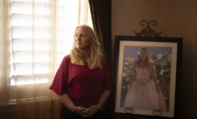 Christine Capelouto, whose daughter, Alexandra, died from a fentanyl overdose, stands for a photo beside her daughter's prom picture in Temecula, Calif., Tuesday, Sept. 17, 2024. (AP Photo/Jae C. Hong)