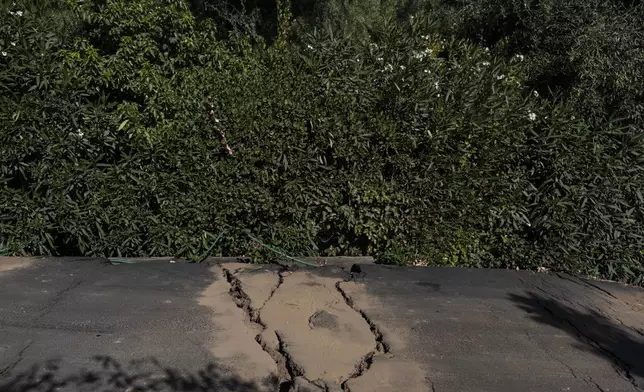 Cracks in the street are filled with dirt in a neighborhood affected by ongoing landslides in Rancho Palos Verdes, Calif., Tuesday, Sept. 3, 2024. (AP Photo/Jae C. Hong)