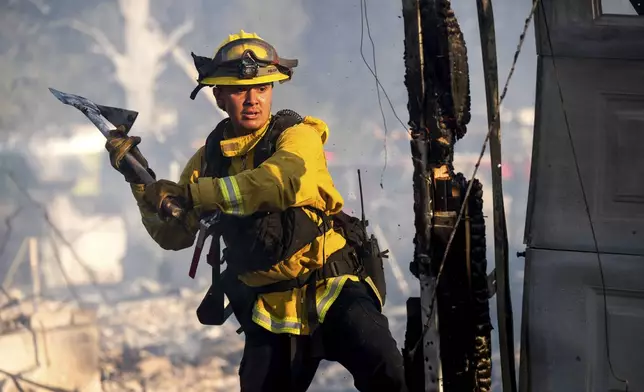 Firefighter Jonathan Lievanos extinguishes hot spots at a home destroyed by the Boyles fire in Clearlake, Calif., on Sunday, Sept. 8, 2024. (AP Photo/Noah Berger)