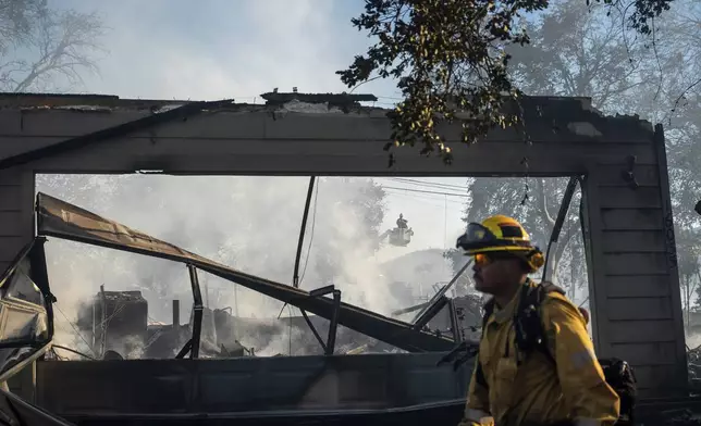 A firefighter passes a home destroyed by the Boyles fire in Clearlake, Calif., on Sunday, Sept. 8, 2024. (AP Photo/Noah Berger)