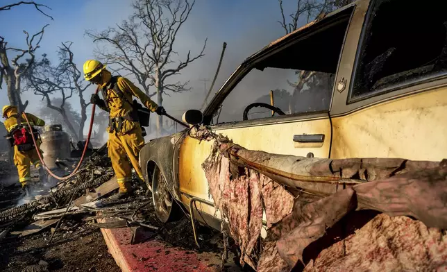 Firefighters extinguish hot spots as the Boyles fire burns in Clearlake, Calif., on Sunday, Sept. 8, 2024. (AP Photo/Noah Berger)