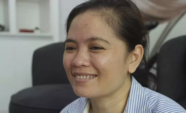 Chhim Sithar, president of the Labor Rights Supported Union of Khmer Employees of NagaWorld, smiles as she meets her staff members in her sister's home at the outskirts of Phnom Penh Cambodia, Monday, Sept. 16, 2024, after the prominent union leader freed from prison on Monday after serving time for her part in a strike against the country’s biggest casino. (AP Photo/Heng Sinith)