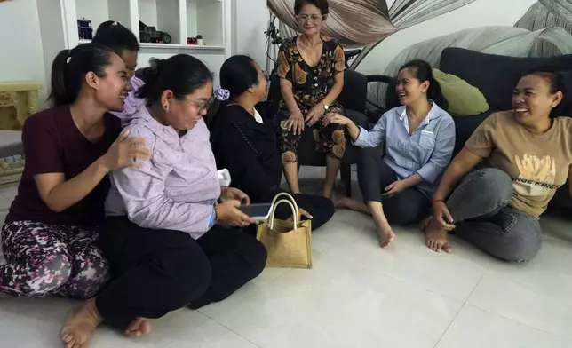 Chhim Sithar, second from right, president of the Labor Rights Supported Union of Khmer Employees of NagaWorld, meets with her mother, center, and her staff members in her sister's home at the outskirts of Phnom Penh Cambodia, Monday, Sept. 16, 2024, after the prominent union leader freed from prison on Monday after serving time for her part in a strike against the country’s biggest casino. (AP Photo/Heng Sinith)