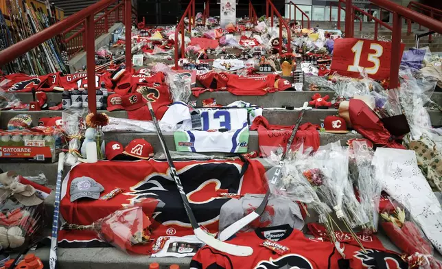 Flowers and memorabilia for former Calgary Flames player Johnny Gaudreau and his brother Matthew rest on the steps outside the Saddledome in Calgary, Alberta., Wednesday, Sept. 4, 2024. (Jeff McIntosh/The Canadian Press via AP)