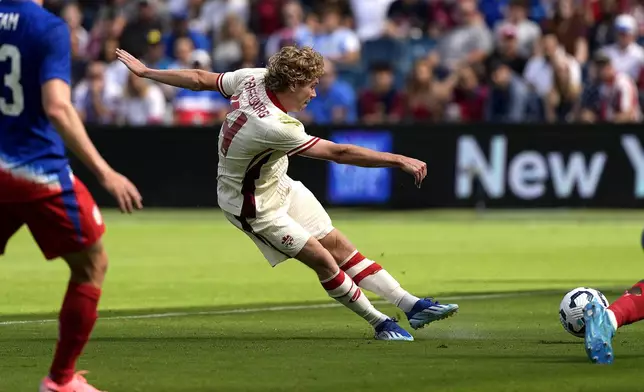 Canada forward Jacob Shaffelburg kicks to score a goal during the first half of an international friendly soccer game against Canada, Saturday, Sept. 7, 2024, in Kansas City, Mo. (AP Photo/Charlie Riedel)