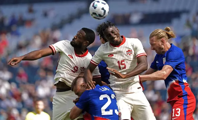 Canada forward Cyle Larin (9) and defender Moïse Bombito (15) compete for a head ball with United States defenders Tim Ream (13) and Kristoffer Lund (23) during the first half of an international friendly soccer game, Saturday, Sept. 7, 2024, in Kansas City, Mo. (AP Photo/Charlie Riedel)