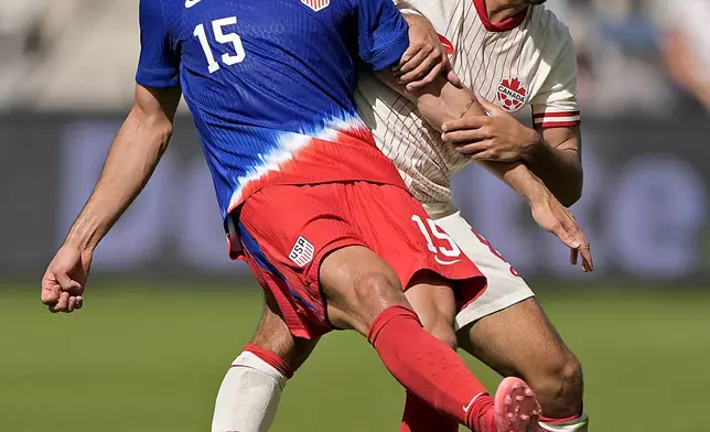 United States midfielder Johnny Cardoso (15) kicks the ball under pressure from Canada midfielder Mathieu Choiniere during the first half of an international friendly soccer game, Saturday, Sept. 7, 2024, in Kansas City, Mo. (AP Photo/Charlie Riedel)