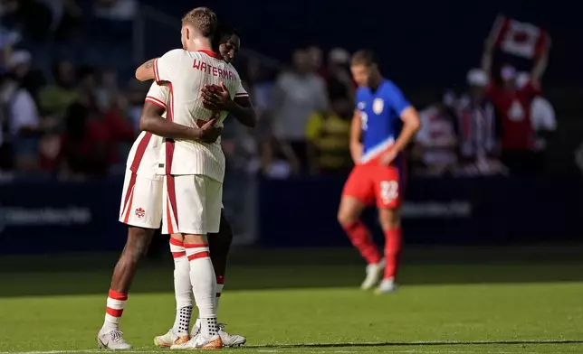 Canada defenders Moïse Bombito, and Joel Waterman (5) celebrate after their international friendly soccer game against United States , Saturday, Sept. 7, 2024, in Kansas City, Mo. Canada won 2-1. (AP Photo/Charlie Riedel)