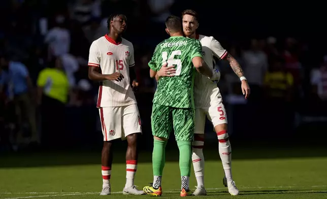 Canada defender Moïse Bombito (15), goalkeeper Maxime Crépeau (16) and defender Joel Waterman (5) celebrate after their international friendly soccer game against United States , Saturday, Sept. 7, 2024, in Kansas City, Mo. Canada won 2-1. (AP Photo/Charlie Riedel)