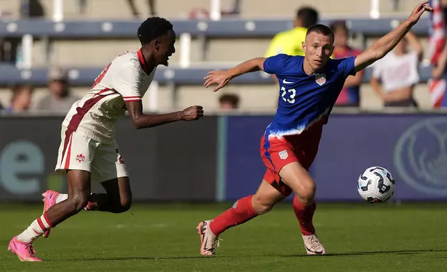 Canada midfielder Ali Ahmed, left, and United States defender Kristoffer Lund (23) chase after the ball during the second half of an international friendly soccer game, Saturday, Sept. 7, 2024, in Kansas City, Mo. Canada won 2-1. (AP Photo/Charlie Riedel)