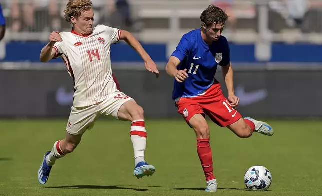 Canada forward Jacob Shaffelburg (14) and United States forward Brenden Aaronson (11) chase after the ball during the first half of an international friendly soccer game, Saturday, Sept. 7, 2024, in Kansas City, Mo. (AP Photo/Charlie Riedel)