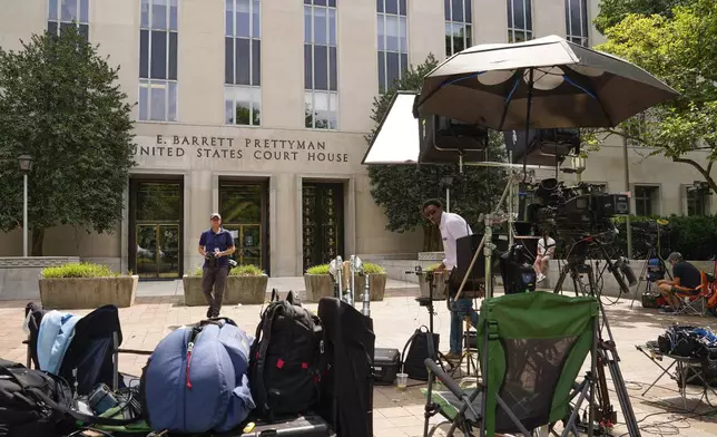 FILE - Members of the media outside E. Barrett Prettyman US Federal Courthouse, Aug. 2, 2023, in Washington. Inside Washington’s federal courthouse, there's no denying the reality of Jan. 6, 2021. Day after day, judges and jurors silently absorb chilling sights and sounds from television screens — of rioters beating police, shattering windows and hunting for lawmakers. Hundreds of cases have systematically documented the weapons wielded, crimes committed, lives altered by physical and emotional damage. (AP Photo/Pablo Martinez Monsivais, File)