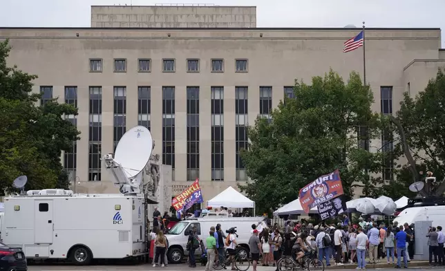 FILE - Media and protesters outside E. Barrett Prettyman US Federal Courthouse, Aug. 2, 2023, in Washington. Inside Washington’s federal courthouse, there's no denying the reality of Jan. 6, 2021. Day after day, judges and jurors silently absorb chilling sights and sounds from television screens — of rioters beating police, shattering windows and hunting for lawmakers. Hundreds of cases have systematically documented the weapons wielded, crimes committed, lives altered by physical and emotional damage. (AP Photo/Pablo Martinez Monsivais, File)