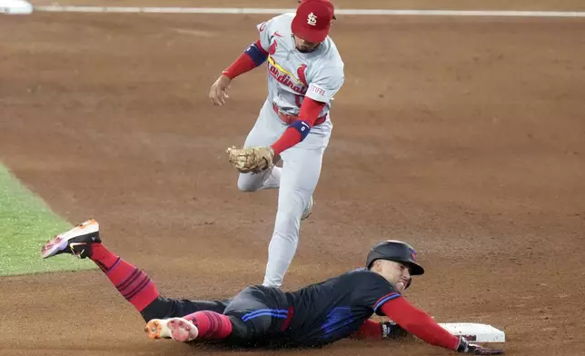 Toronto Blue Jays' designated hitter George Springer, bottom, steals second base as St. Louis Cardinals' shortstop Masyn Winn, top, cannot make a tag in the fourth inning during baseball game action in Toronto, Friday Sept. 13, 2024. (Chris Young/The Canadian Press via AP)