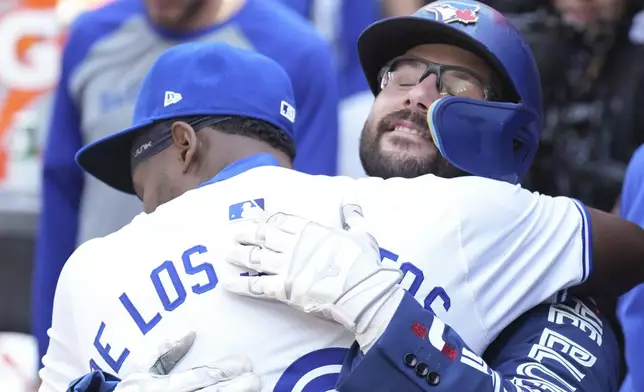 Toronto Blue Jays' Davis Schneider celebrates in the dug out with teammate Luis De Los Santos after hitting a home run off St. Louis Cardinals pitcher Kyle Gibson during third inning interleague MLB baseball action in Toronto, Saturday, Sept. 14, 2024. (Chris Young/The Canadian Press via AP)