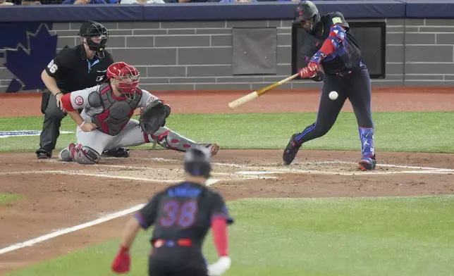 Toronto Blue Jays' Vladimir Guerrero Jr., right, hits an RBI single against the St. Louis Cardinals in the fourth inning during baseball game action in Toronto, Friday Sept. 13, 2024. (Chris Young/The Canadian Press via AP)