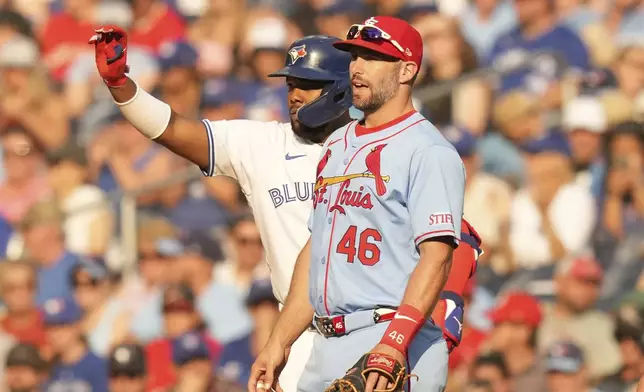 Toronto Blue Jays' Vladimir Guerrero Jr. gestures for the ball after hitting an RBI single, his 500th RBI as a Blue Jay, as he stands with St. Louis Cardinals first baseman Paul Goldschmidt during seventh inning interleague MLB baseball action in Toronto, Saturday, September 14, 2024. (Chris Young/The Canadian Press via AP)