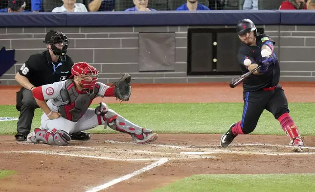 Toronto Blue Jays' Alejandro Kirk, right, hits a go-ahead single against the St. Louis Cardinals in the fourth inning during baseball game action in Toronto, Friday Sept. 13, 2024. (Chris Young/The Canadian Press via AP)