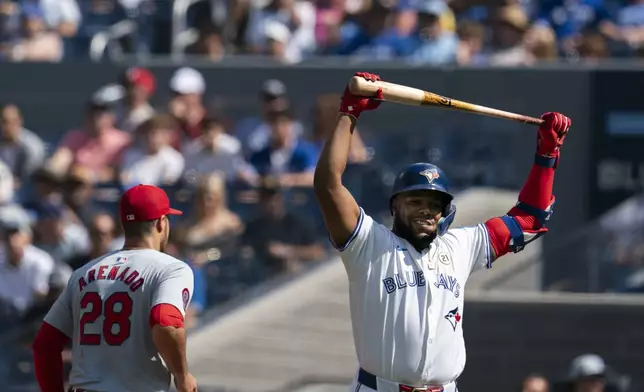 Toronto Blue Jays' Vladimir Guerrero Jr., right, reacts during first-inning baseball game action against the St. Louis Cardinals in Toronto, Sunday Sept. 15, 2024. (Paige Taylor White/The Canadian Press via AP)