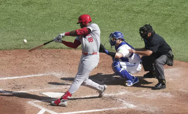 St. Louis Cardinals' Jordan Walker, left, hits an RBI double in front of Toronto Blue Jays catcher Brian Serven, center, during fifth-inning baseball game action in Toronto, Sunday Sept. 15, 2024. (Chris Young/The Canadian Press via AP)