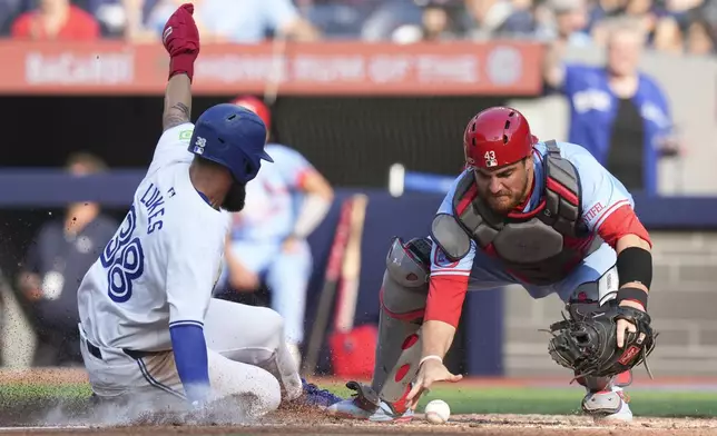 St. Louis Cardinals catcher Pedro Pages reaches for the ball as Toronto Blue Jays' Nathan Lukes scores during sixth inning interleague MLB baseball action in Toronto, Saturday, September 14, 2024. (Chris Young/The Canadian Press via AP)