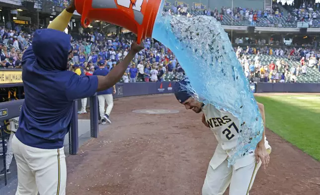 Milwaukee Brewers' Willy Adames, right, is doused after a baseball game against the St. Louis Cardinals, Monday, Sept. 2, 2024, in Milwaukee. (AP Photo/Jeffrey Phelps)