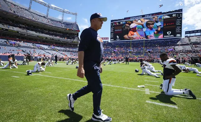 Denver Broncos head coach Sean Payton walks on the field as players warm up prior to a preseason NFL football game against the Arizona Cardinals, Sunday, Aug. 25, 2024, in Denver. (AP Photo/Jack Dempsey)