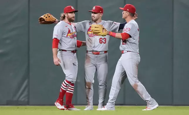 St. Louis Cardinals' Brendan Donovan, left, Michael Siani (63) and Lars Nootbaar celebrate after a victory against the San Francisco Giants in a baseball game Friday, Sept. 27, 2024, in San Francisco. (AP Photo/Tony Avelar)