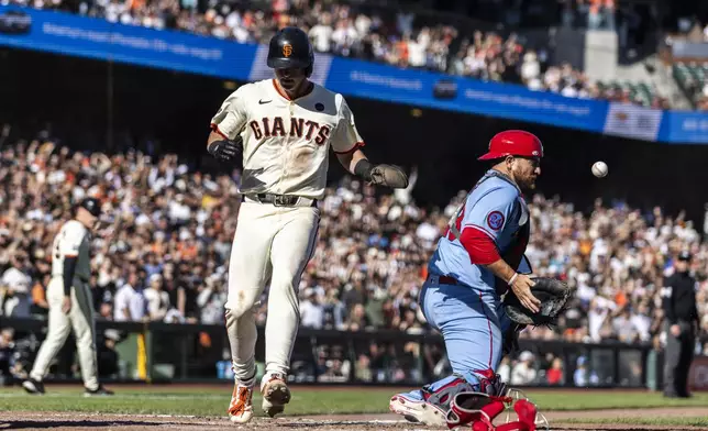 San Francisco Giants' Tyler Fitzgerald (49) scores the game-winning run on a throwing error by St. Louis Cardinals pitcher Matthew Liberatore (52) during the eighth inning of a baseball game in San Francisco, Saturday, Sept. 28, 2024. (Stephen Lam/San Francisco Chronicle via AP)