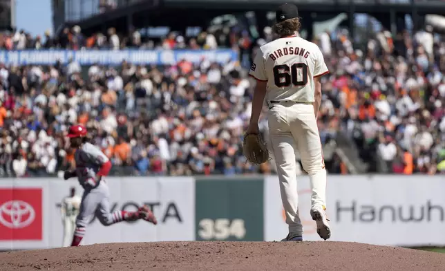 San Francisco Giants pitcher Hayden Birdsong (60) stands on the mound as St. Louis Cardinals' Brendan Donovan, back left, rounds the bases after hitting a solo home during the third inning of a baseball game Sunday, Sept. 29, 2024, in San Francisco. (AP Photo/Tony Avelar)