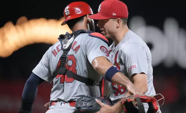 St. Louis Cardinals pitcher Ryan Helsley, right, hugs catcher Iván Herrera (48) after a victory against the San Francisco Giants in a baseball game Friday, Sept. 27, 2024, in San Francisco. (AP Photo/Tony Avelar)