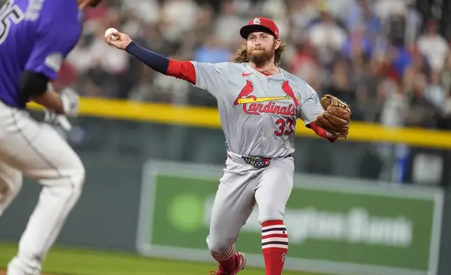 St. Louis Cardinals second baseman Brendan Donovan, back, throws over Colorado Rockies' Jacob Stallings after forcing him out at second base on a double play hit into by Jordan Beck in the fifth inning of a baseball game Tuesday, Sept. 24, 2024, in Denver. (AP Photo/David Zalubowski)