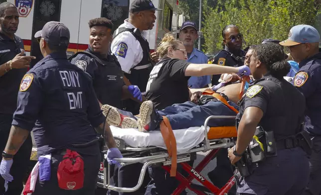 First responders tend to a man injured during a shooting at the West Indian Parade, Monday, Sept. 2, 2024, in the Brooklyn borough of New York. (Nancy Siesel via AP)